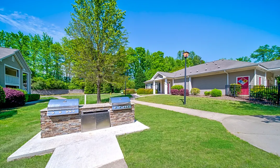 a patio with two barbecue pits in front of a house