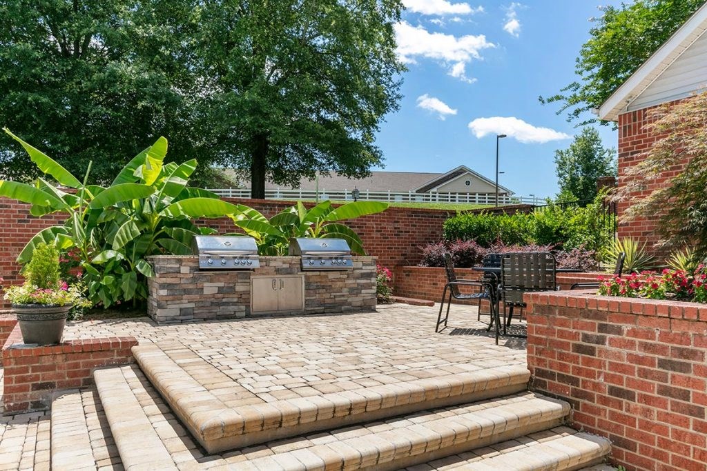 a brick patio with a grill and barbecue