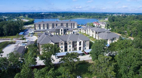 A large building complex with a lake in the background.
