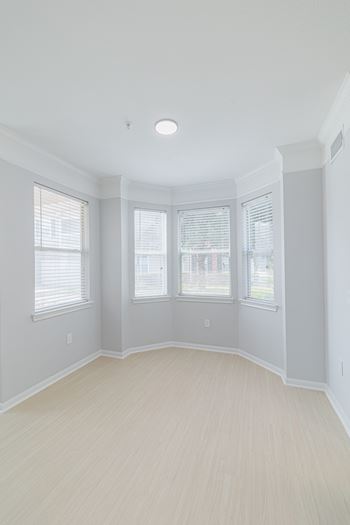 A room with a window and a wooden floor.