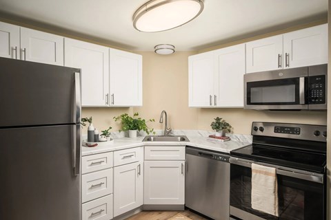 A kitchen with white cabinets and stainless steel appliances.