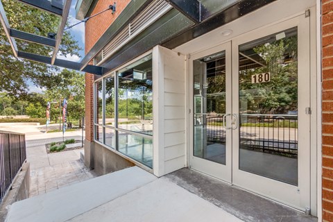 the entrance to a building with glass doors and a sidewalk