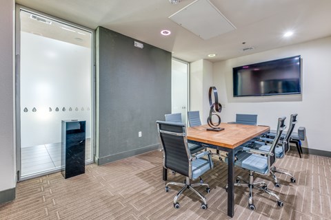 A conference room with a wooden table and chairs.
