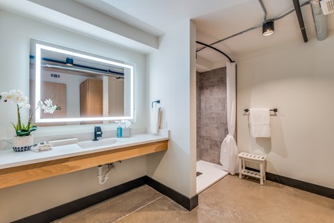 A bathroom with a large mirror and a white sink.