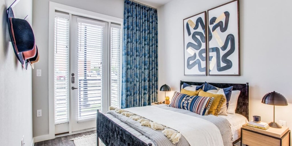 A bedroom with a large bed and a painting on the wall.