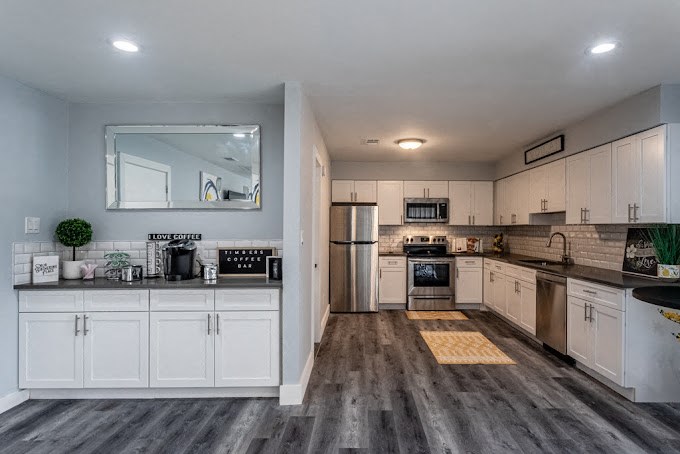a kitchen with white cabinets and stainless steel appliances