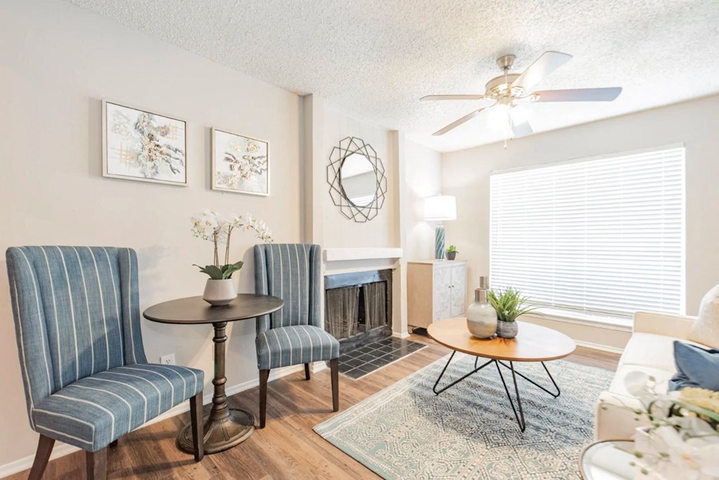 a living room with a fireplace and a ceiling fan
