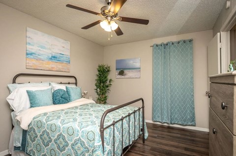 a bedroom with a bed and a ceiling fan