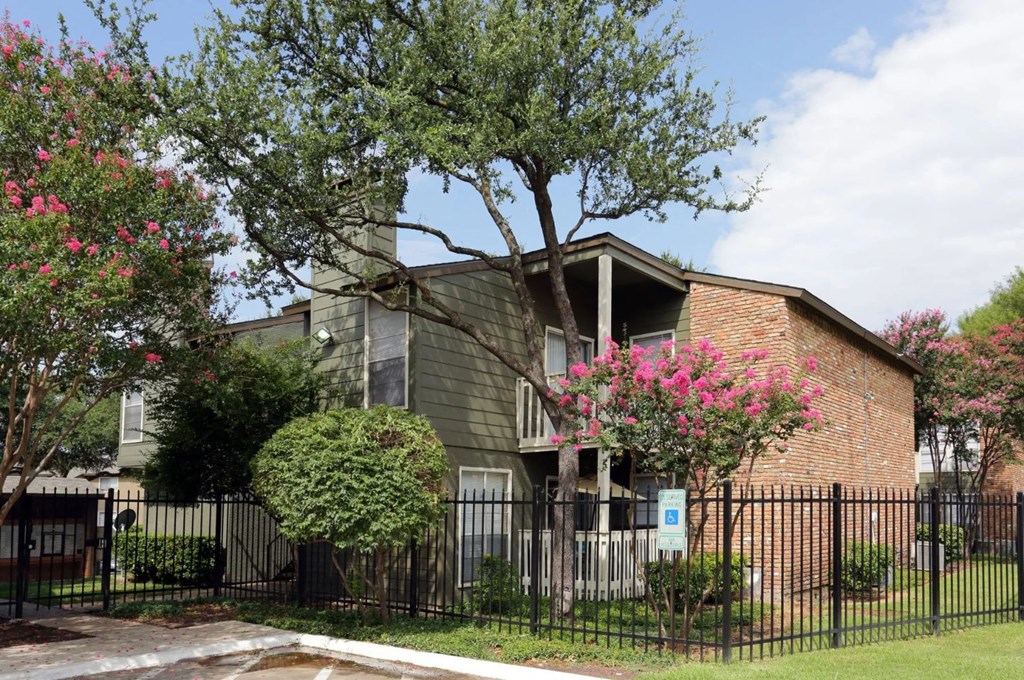 an apartment building with a black fence in front of it