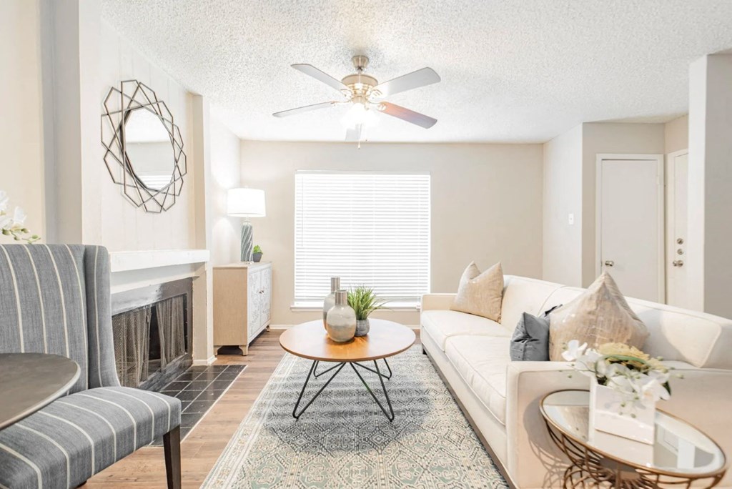 a living room with a fireplace and a ceiling fan