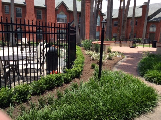 a black wrought iron fence in front of a brick building