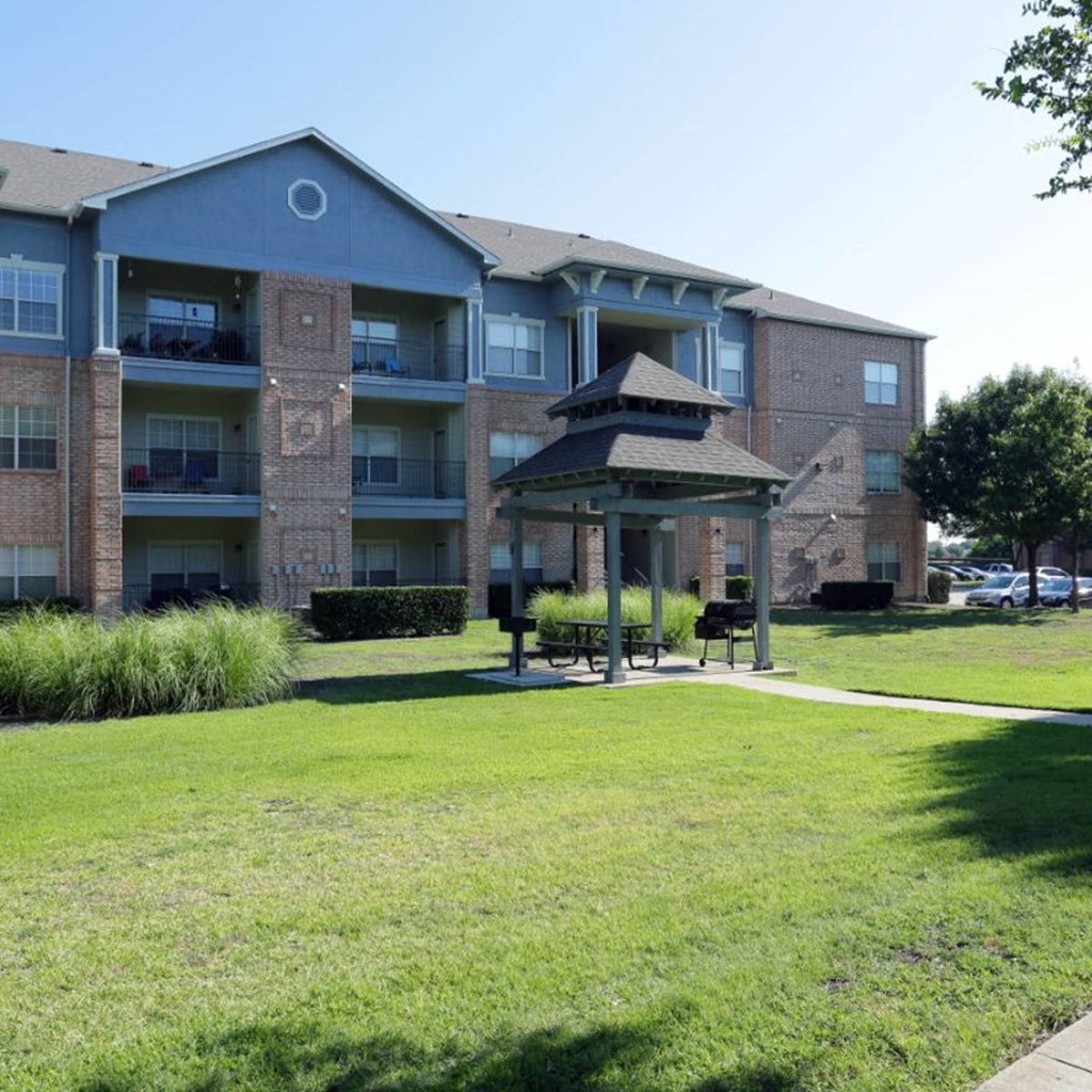 a gazebo sits in front of an apartment building