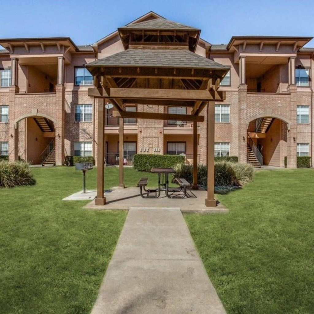 a patio with a picnic table in front of a building