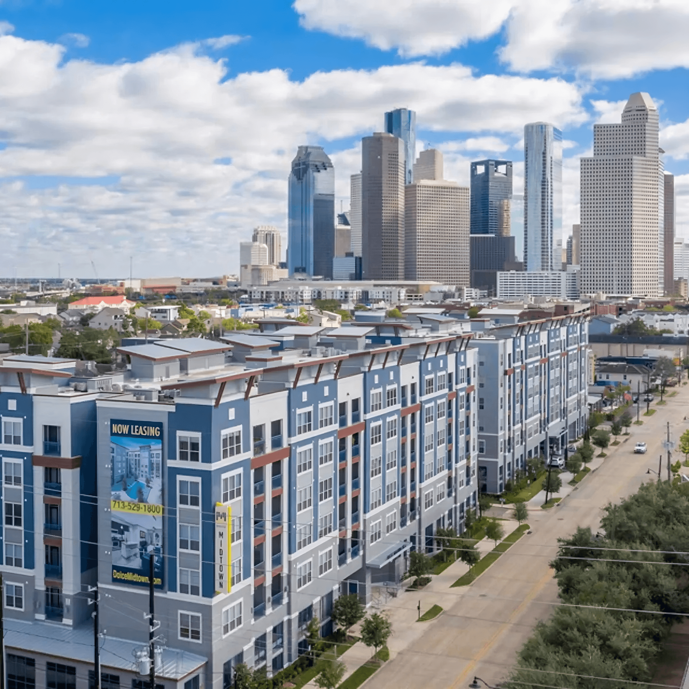 an aerial view of an apartment building with a city in the background