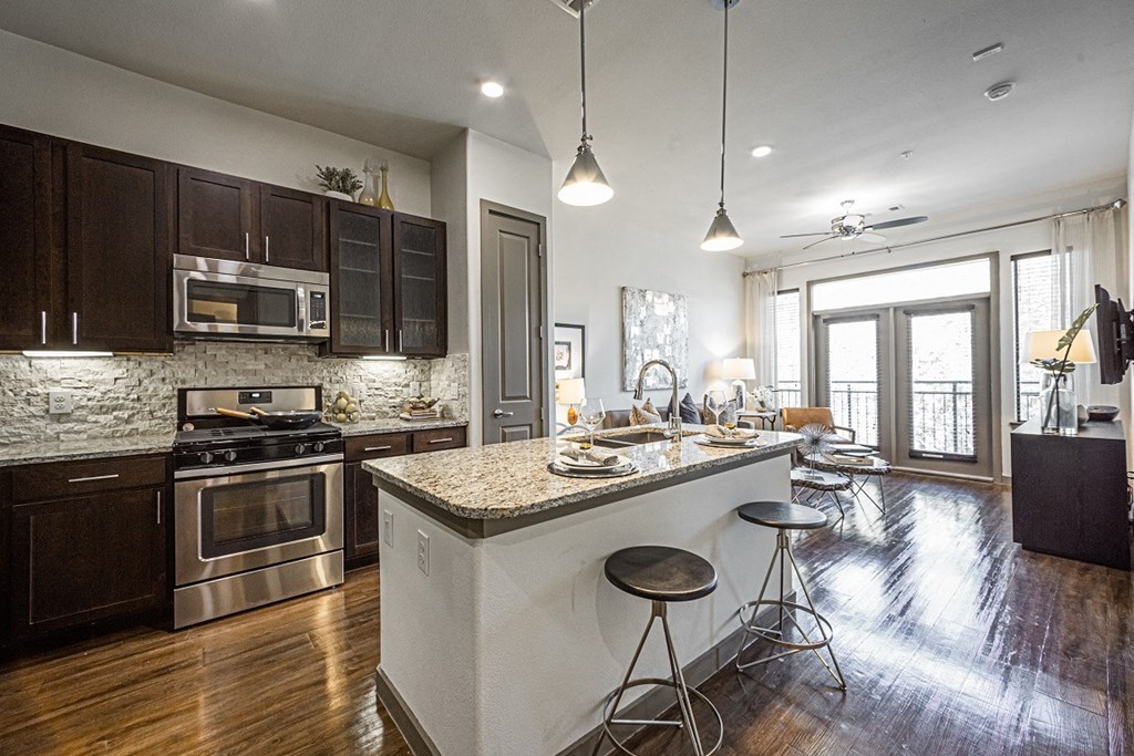 A modern kitchen with dark wood cabinets and a white island.