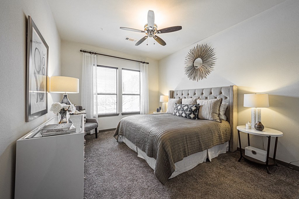 A bedroom with a large bed and a ceiling fan.