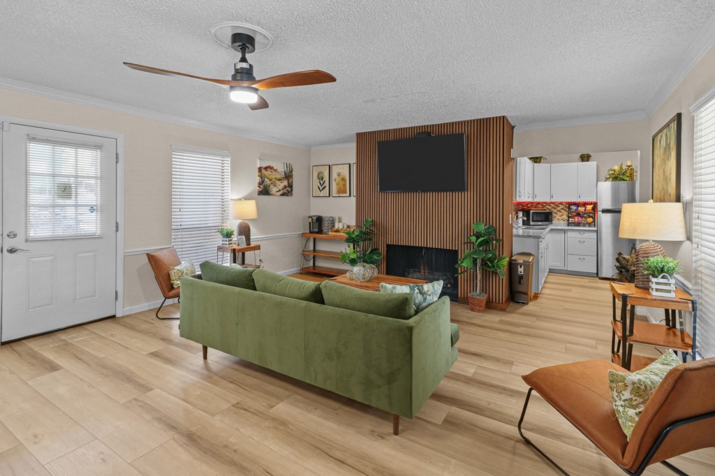 a living room with a green couch and a ceiling fan