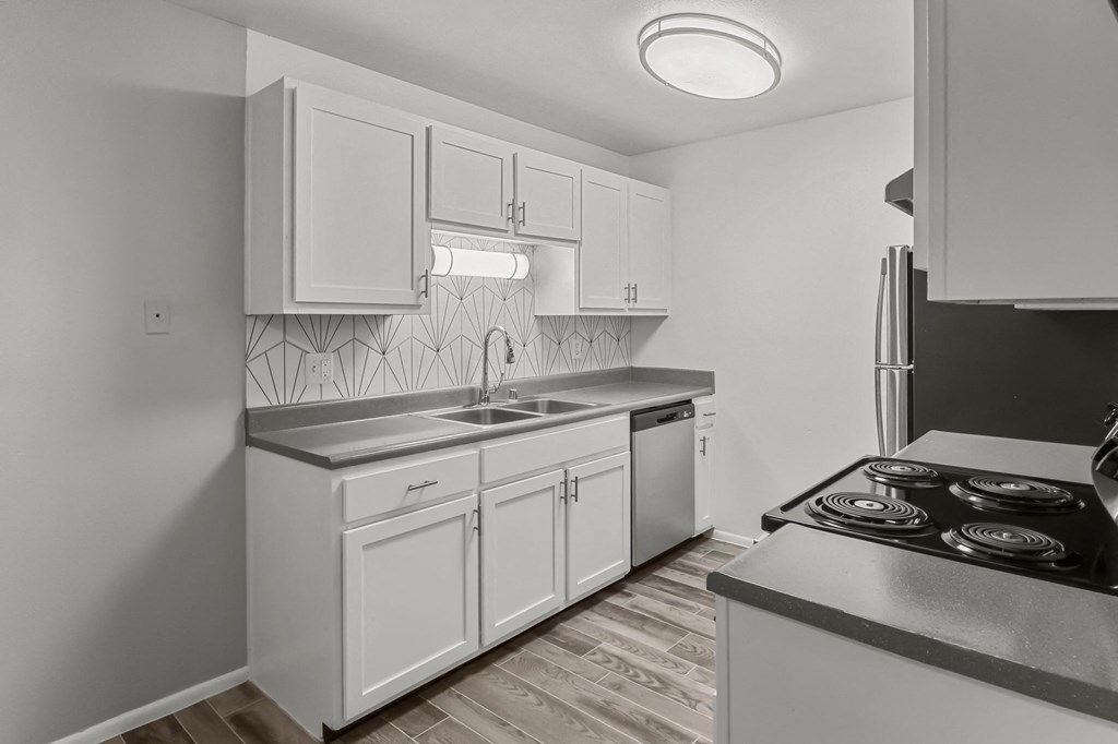 an empty kitchen with white cabinets and stainless steel appliances