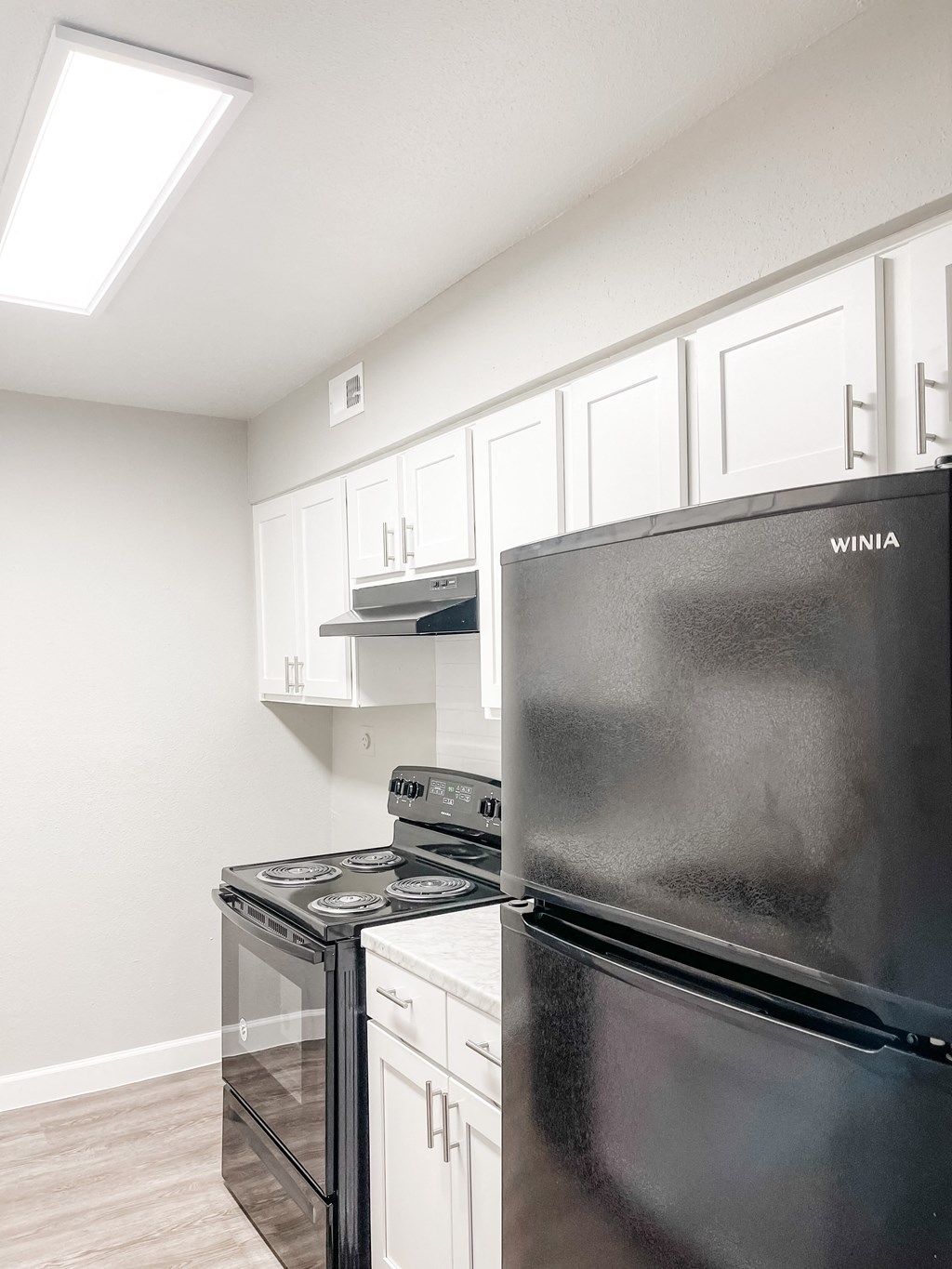 a kitchen with stainless steel appliances and white cabinets