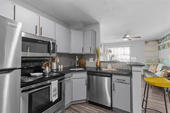 A kitchen with a stove top oven and a refrigerator.