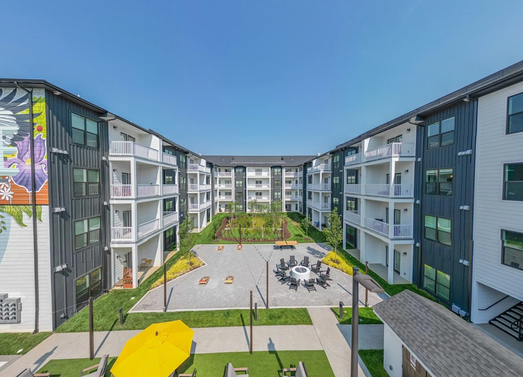 A modern apartment complex with a central courtyard and playground.