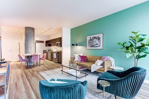 A living room with a blue chair and a green plant.