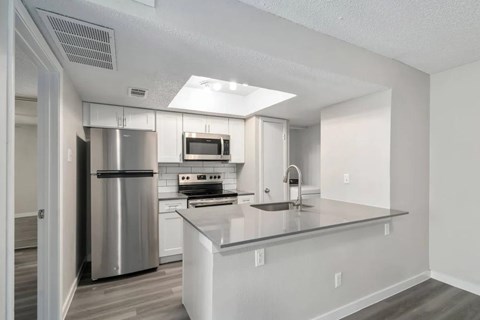 A modern kitchen with stainless steel appliances and a central island.