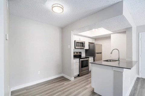 A kitchen with white cabinets and a sink.