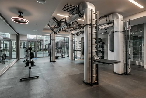 A gym with a variety of equipment including treadmills, weights, and exercise machines.