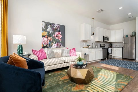 A living room with a couch, a coffee table, and a painting on the wall.