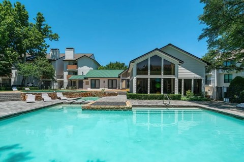 A swimming pool in front of a house.