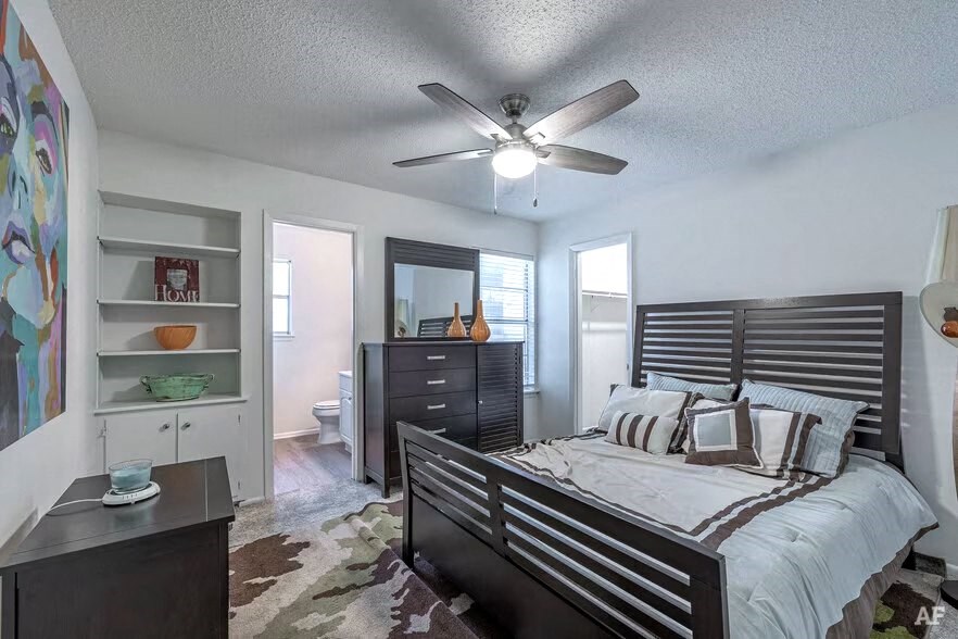 a bedroom with a bed and a ceiling fan