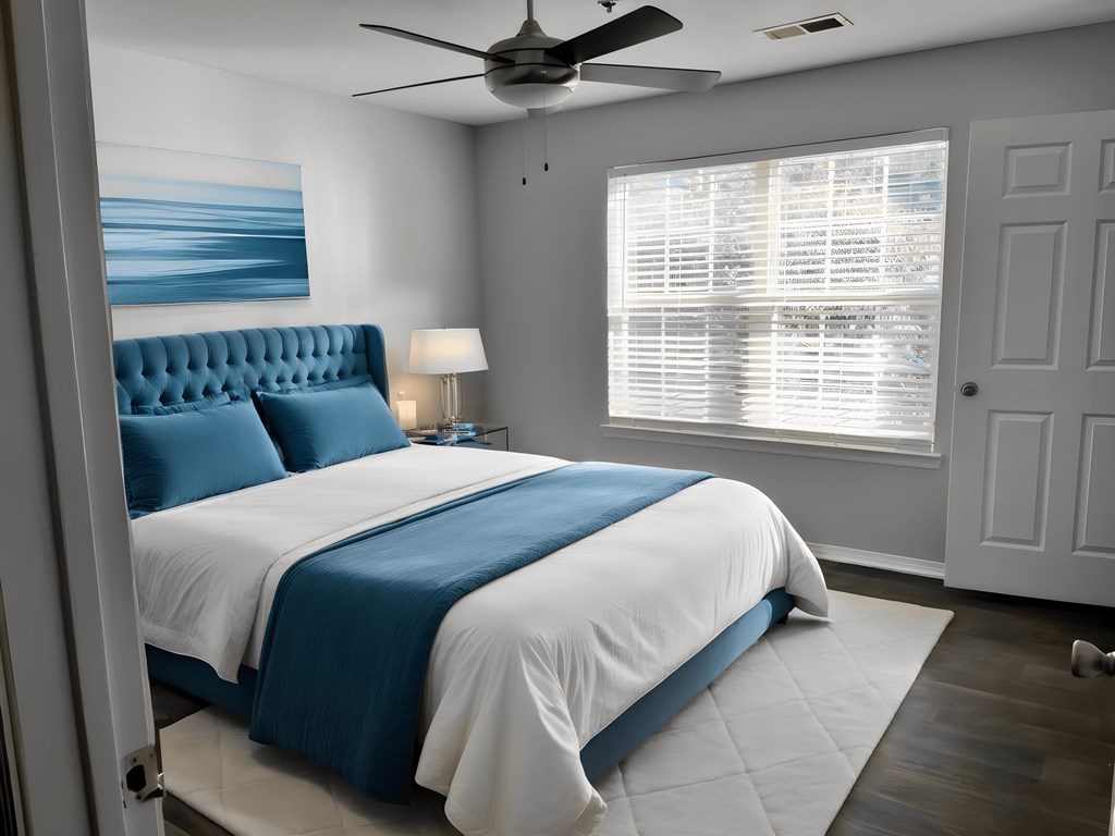 a bedroom with a blue and white bed and a ceiling fan