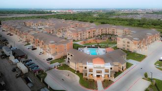 an aerial view of a large apartment complex with a pool in the middle