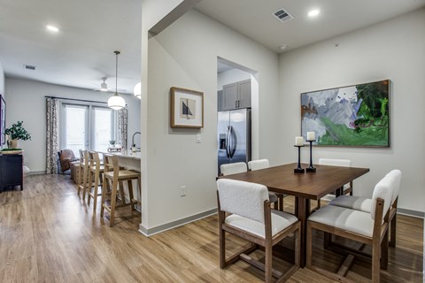 A dining room with a wooden table and chairs.