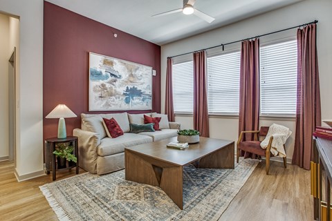 A living room with a couch, chair, and a painting on the wall.