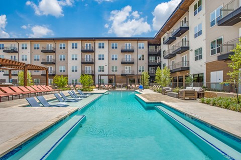 A swimming pool in front of apartment buildings.
