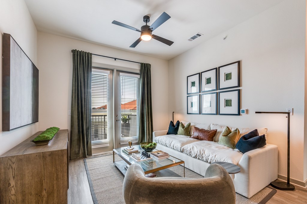 A living room with a white couch and a ceiling fan.
