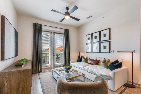 A living room with a white couch and a ceiling fan.
