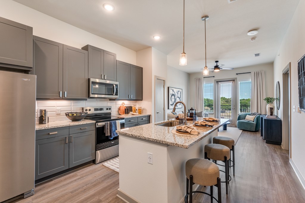 A modern kitchen with a large island and bar stools.
