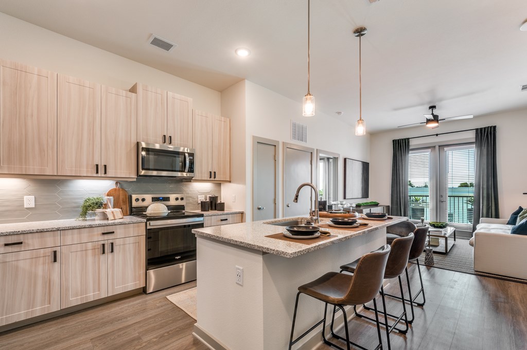 A modern kitchen with wooden cabinets and a large island.