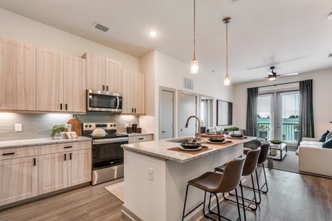 A modern kitchen with wooden cabinets and a large island.