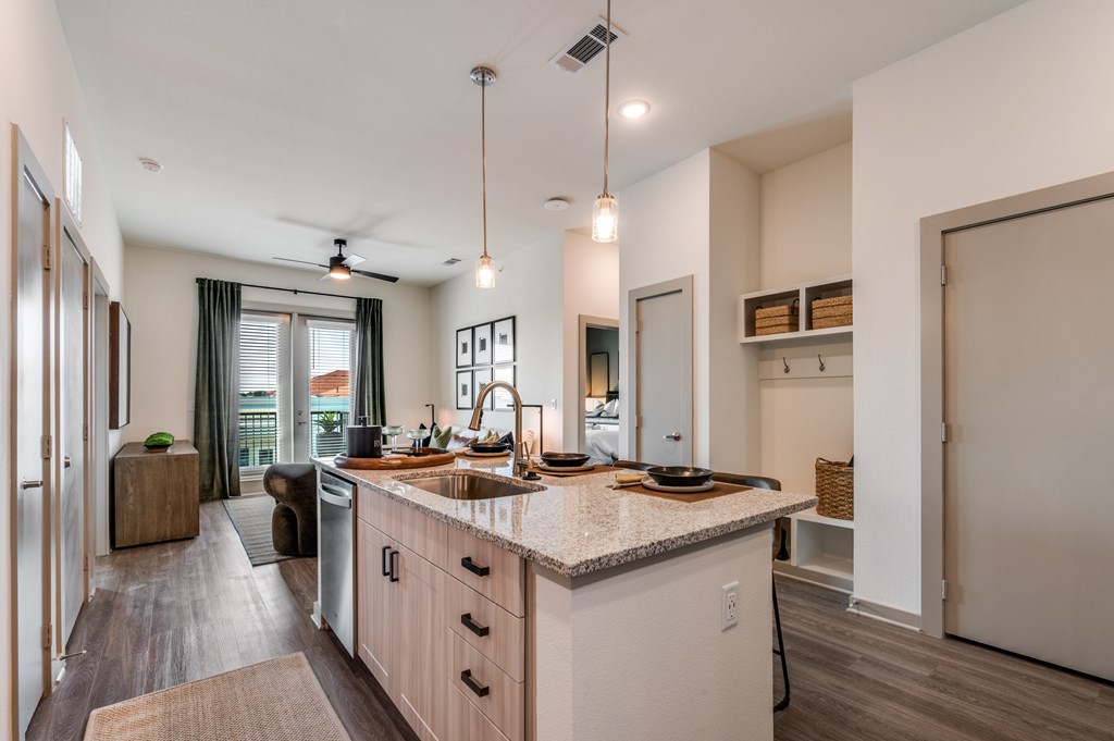 A modern kitchen with a large island and pendant lights.