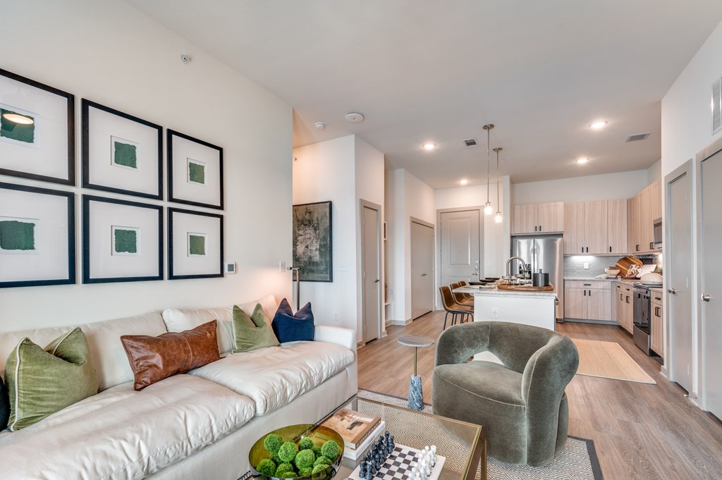 A modern living room with a white sofa and a green armchair.