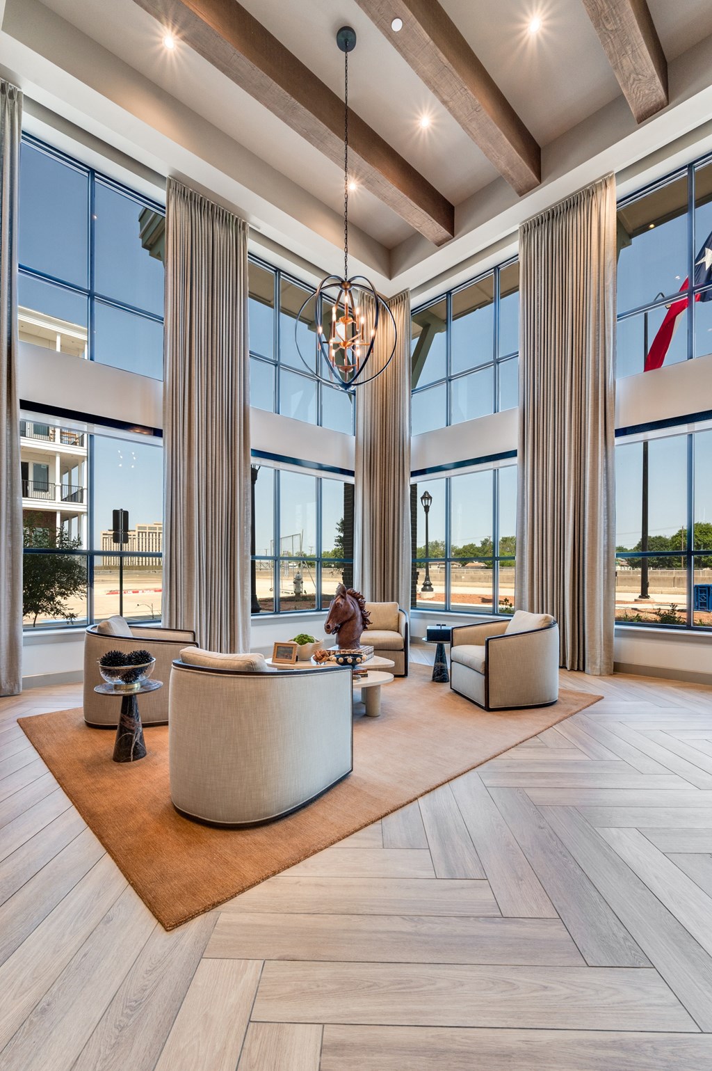 A large, modern living room with a high ceiling and a large chandelier.