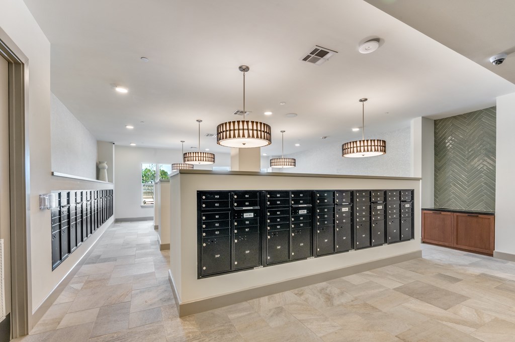 A long hallway with a row of mailboxes on the wall.