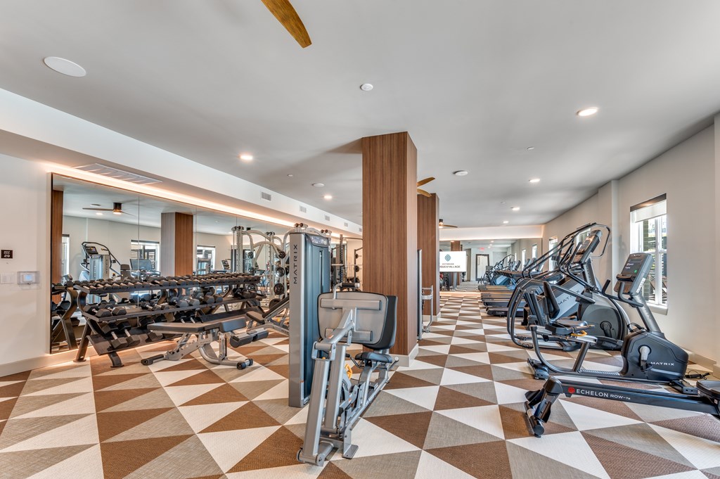 A gym with a variety of equipment including treadmills, weights, and exercise machines.
