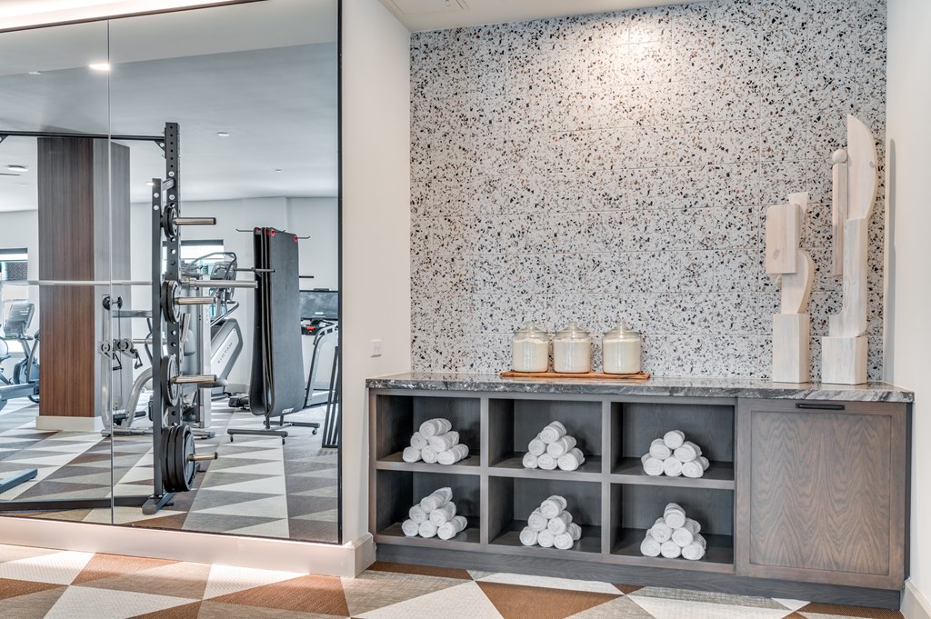 A bathroom with a tiled floor and a wall with a speckled pattern.