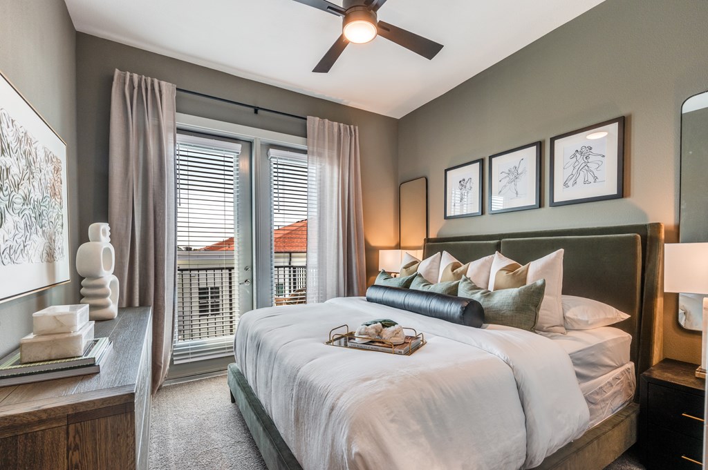 A bedroom with a large bed and a ceiling fan.