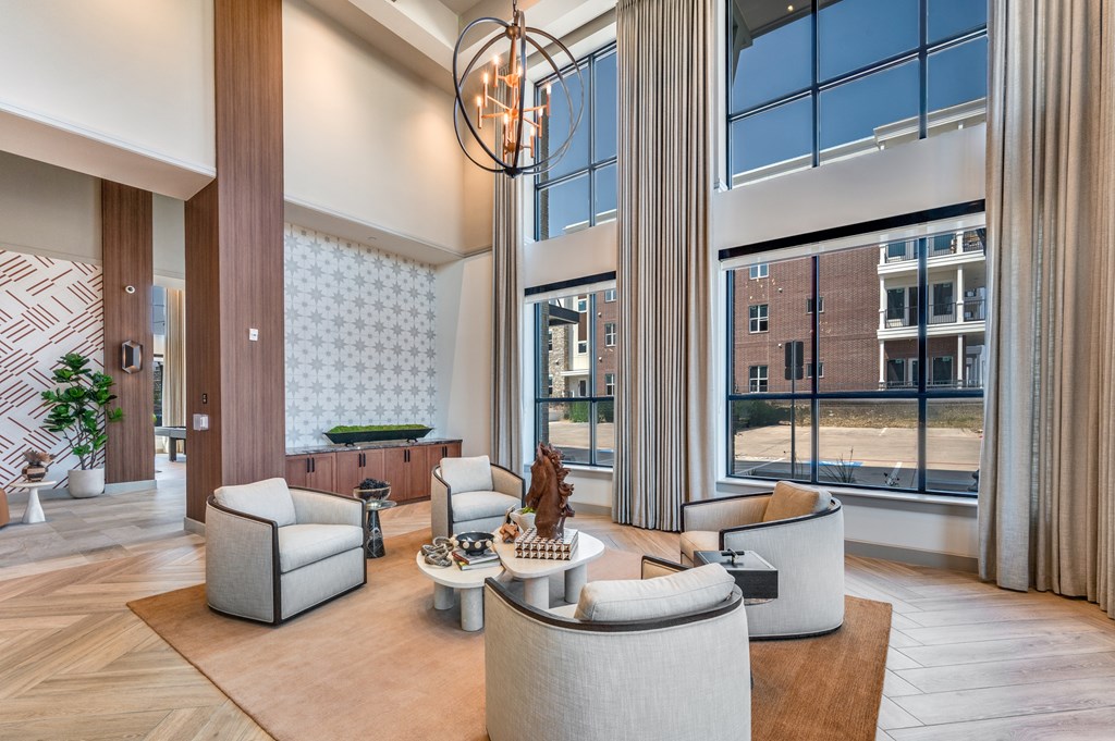 A modern living room with a large window and a view of a building outside.